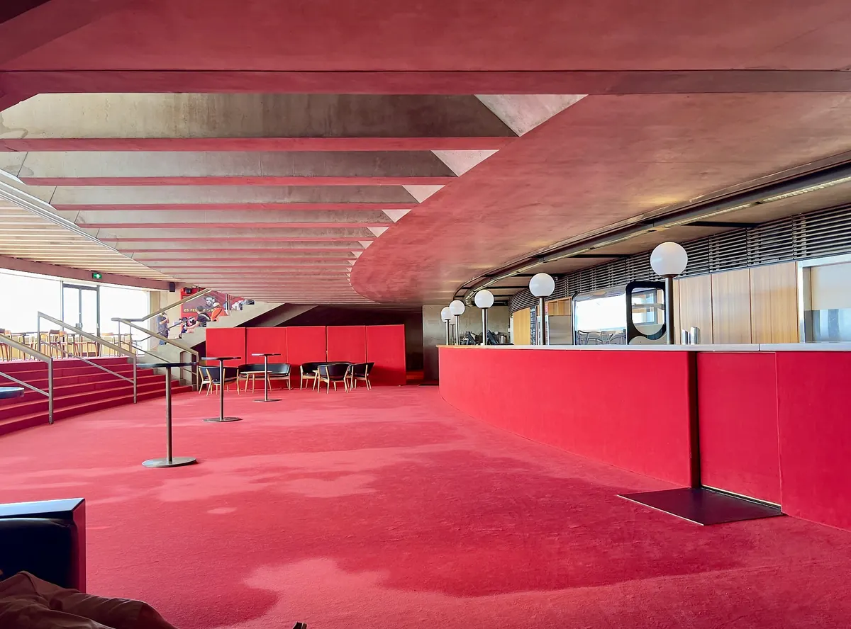 Un bar e un'area salotto in un foyer del Joan Sutherland Theatre, con moquette e pareti rosse e lampade bianche rotonde
